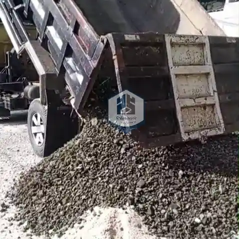 Proses bongkar muat batu base course untuk proyek konstruksi di Bekasi