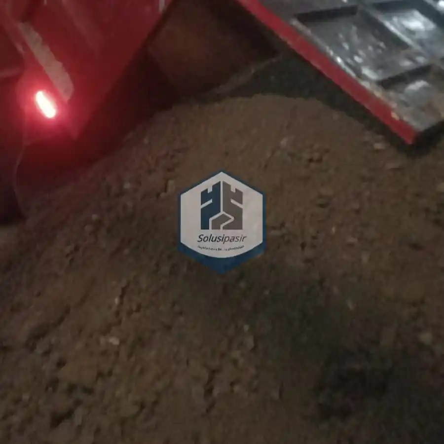 Pengiriman dan bongkar muat material batu base course di area Bogor