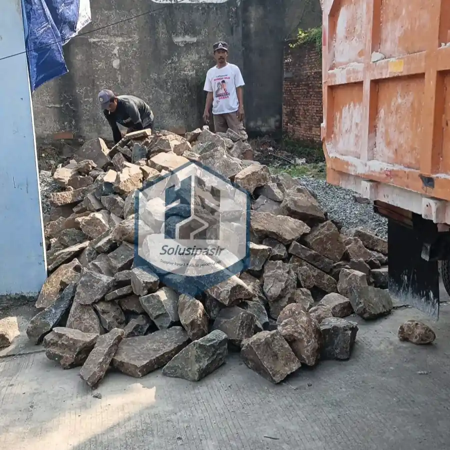 Pengiriman dan bongkar muat material batu belah pondasi di area Bogor