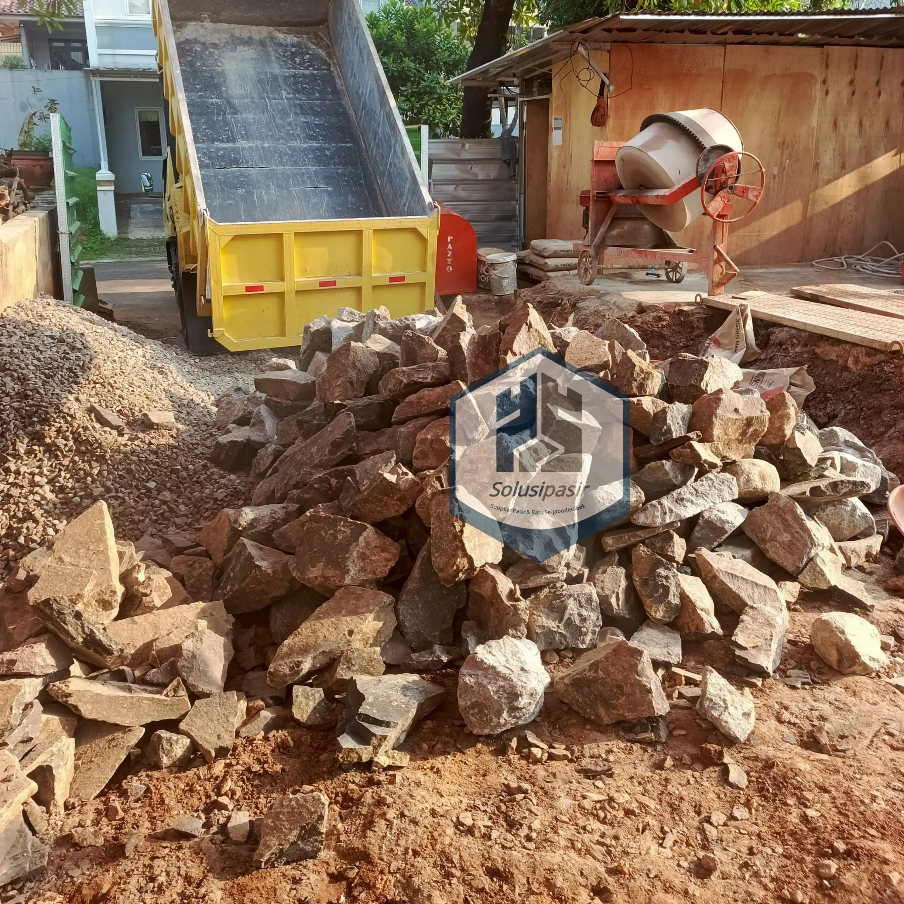 Pekerja mengawasi proses bongkar muat batu belah pondasi di Tangerang