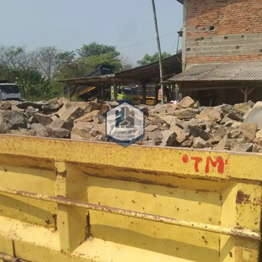 Proses bongkar muat batu makadam untuk proyek konstruksi di Bekasi