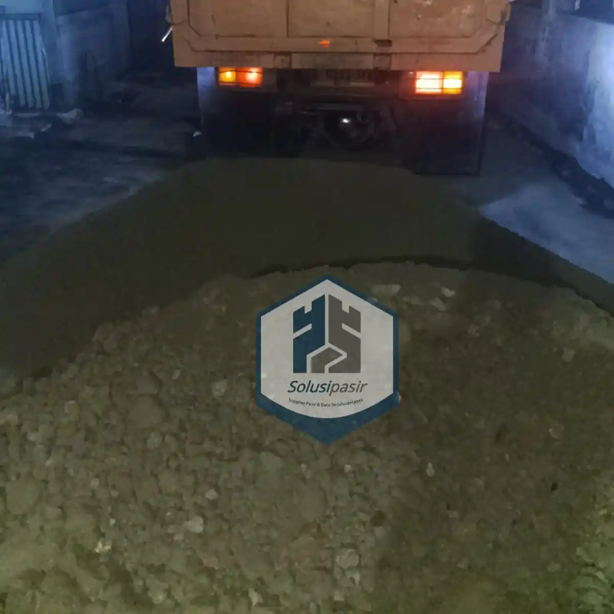 Truk logistik sedang melakukan bongkar muat batu sirdam di Depok