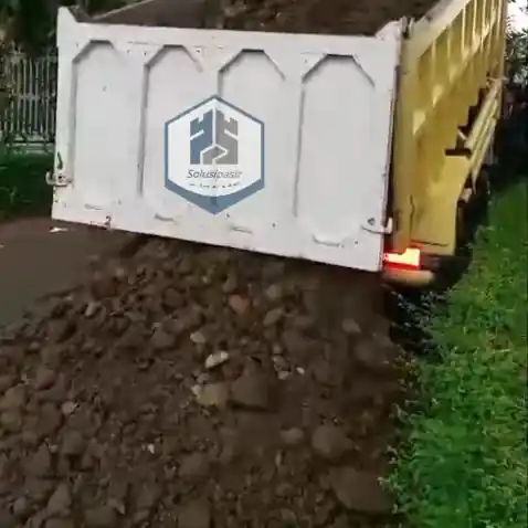 Truk logistik sedang melakukan bongkar muat batu sirtu di Depok
