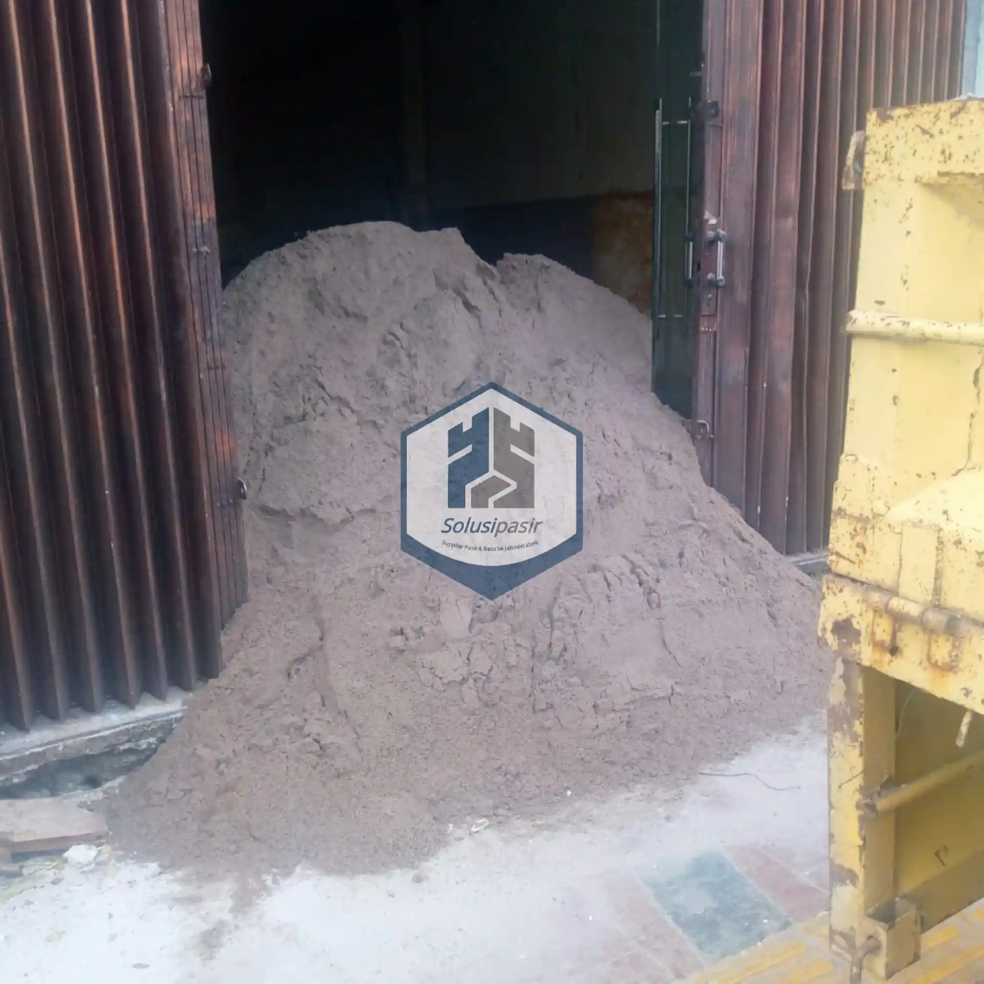 Truk logistik sedang melakukan bongkar muat pasir bangka cream di Depok