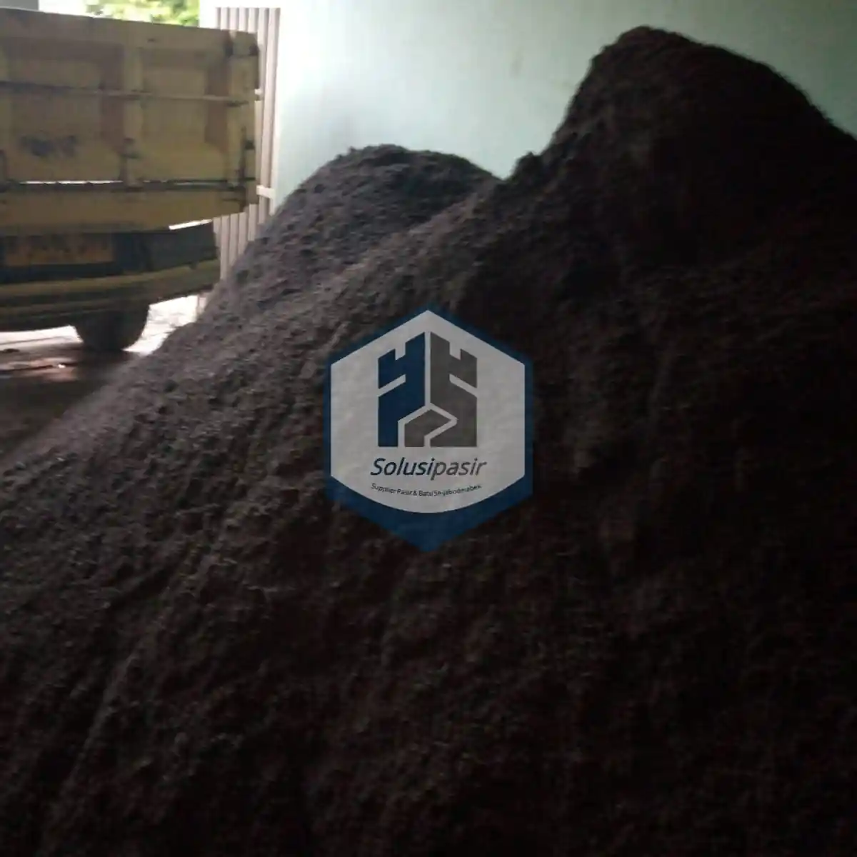 Proses bongkar muat pasir hitam cor untuk proyek konstruksi di Bekasi