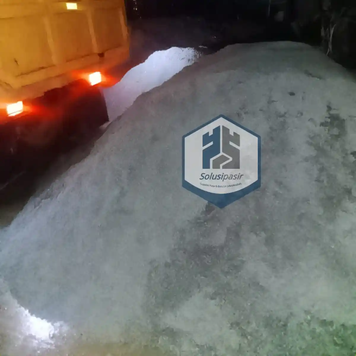 Truk logistik sedang melakukan bongkar muat pasir hitam cor di Depok