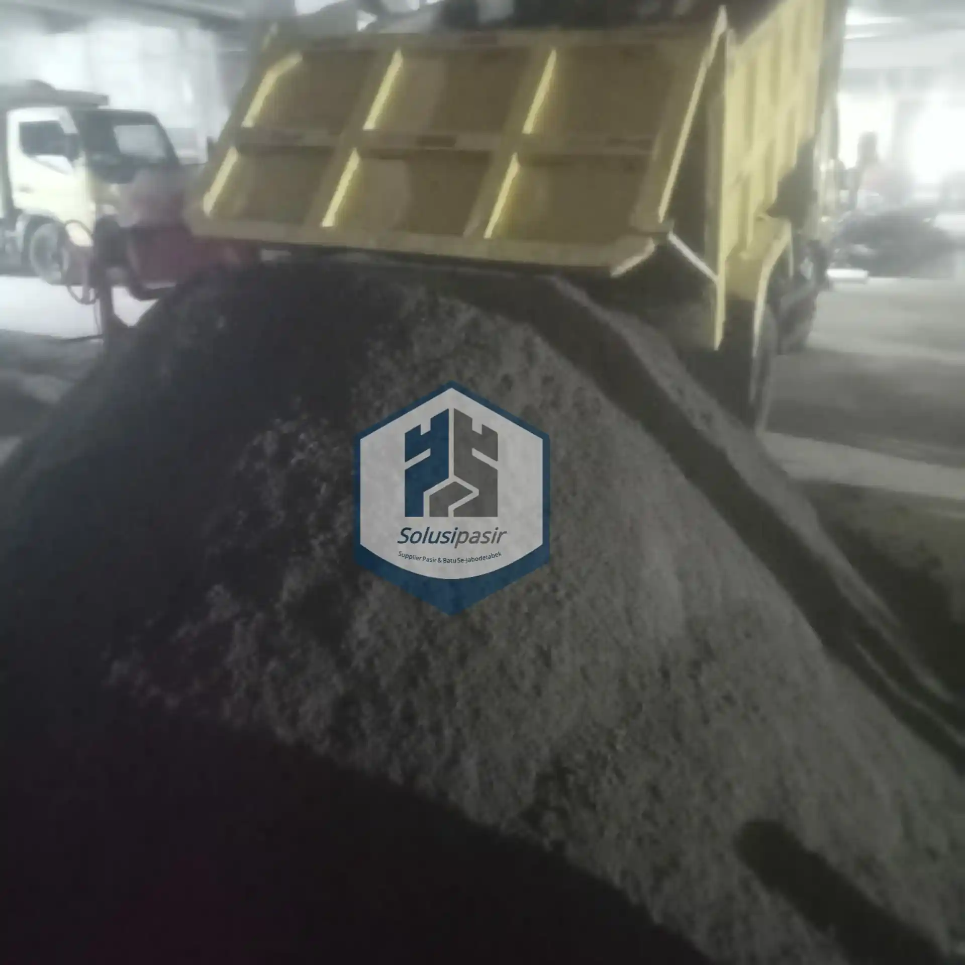 Proses bongkar muat pasir rangkas untuk proyek konstruksi di Bekasi