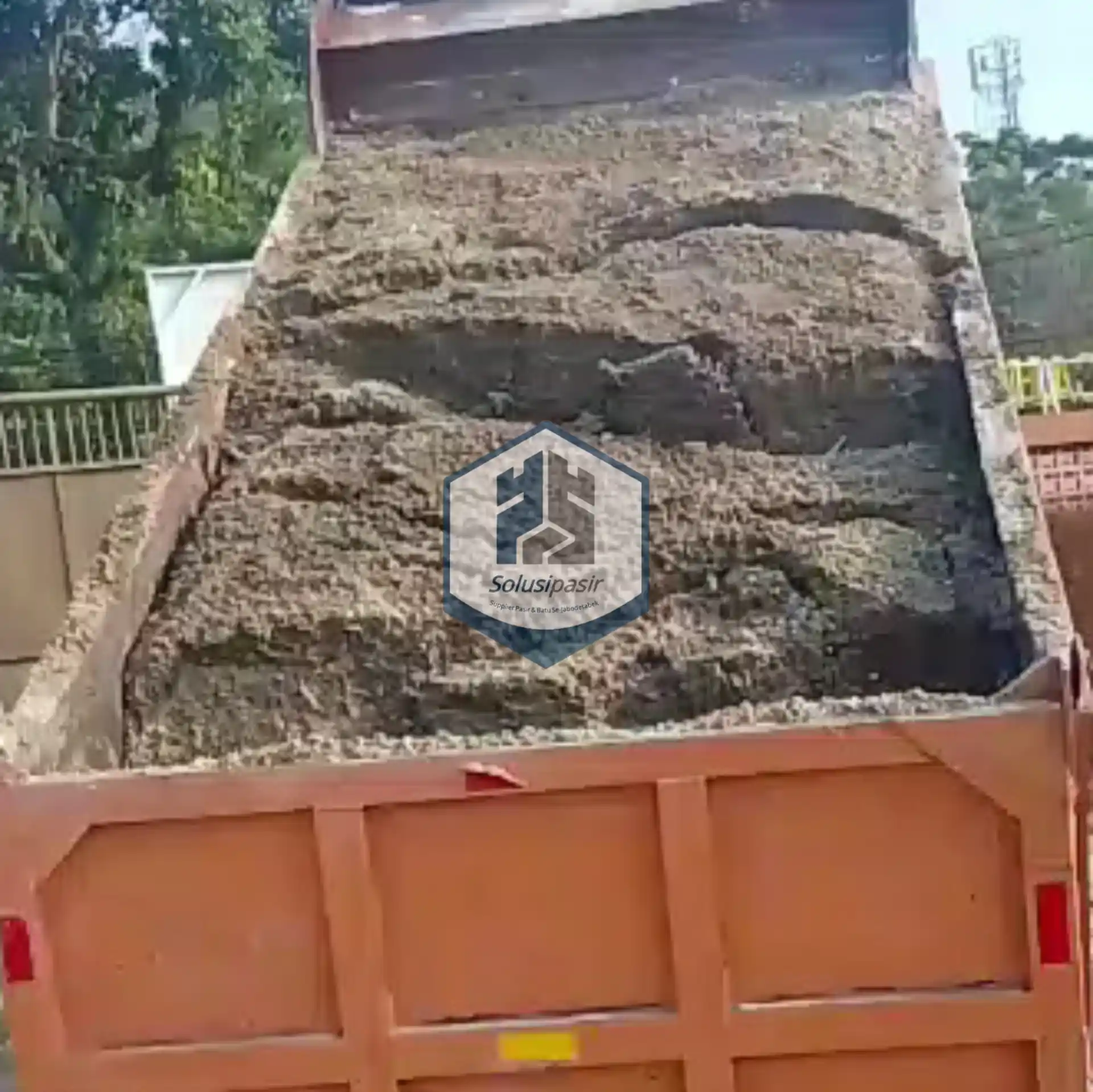 Proses bongkar muat pasir urug untuk proyek konstruksi di Bekasi